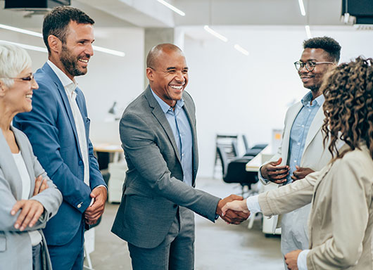Manager shaking employee's hand in dealership